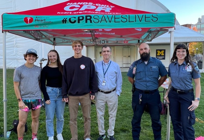 A photo of six people at a CPR training event, including Ethan King whose life was saved by bystanders and first responders who used CPR on him.