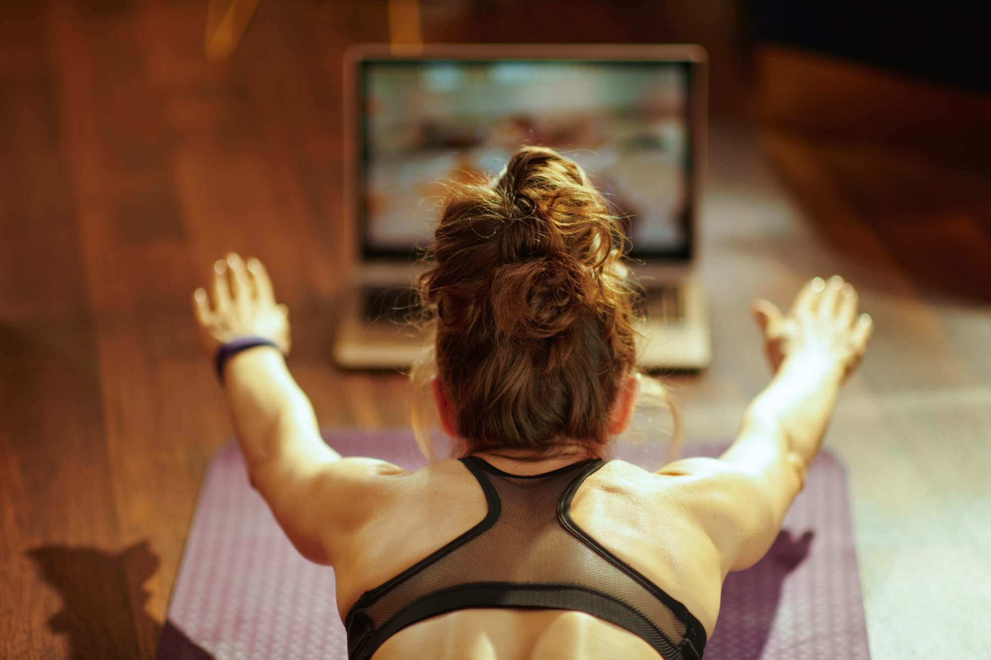 woman watching fit tutorial on internet while doing exercises